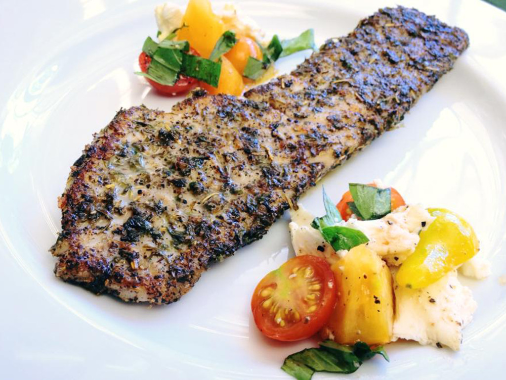 Rockfish fillet, blackened. Served with heirloom tomato and mozzarella salad. Photo CC-BY-4.0: Ben Young Landis.